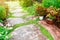 BeautifulÃ‚Â garden and stone path and  blooming flower and tree with green leaves